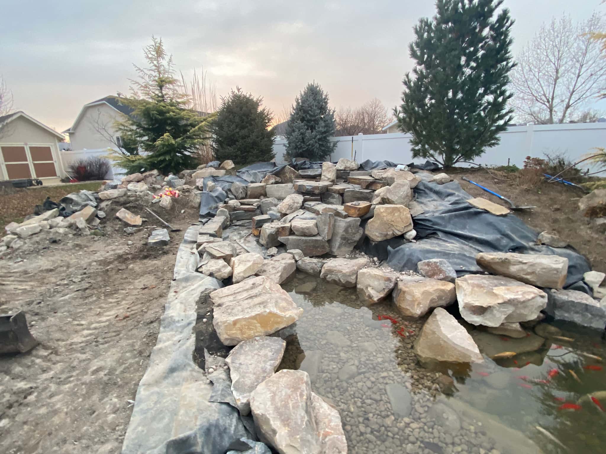 Finished pond construction with water filling and edge detailing