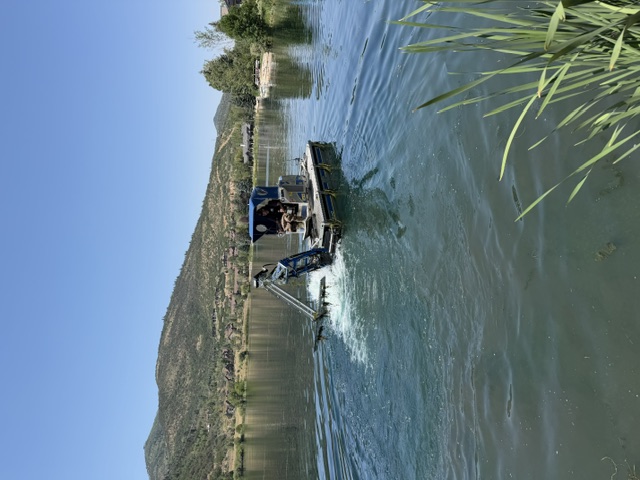 Mechanical aquatic harvester operating on a large pond