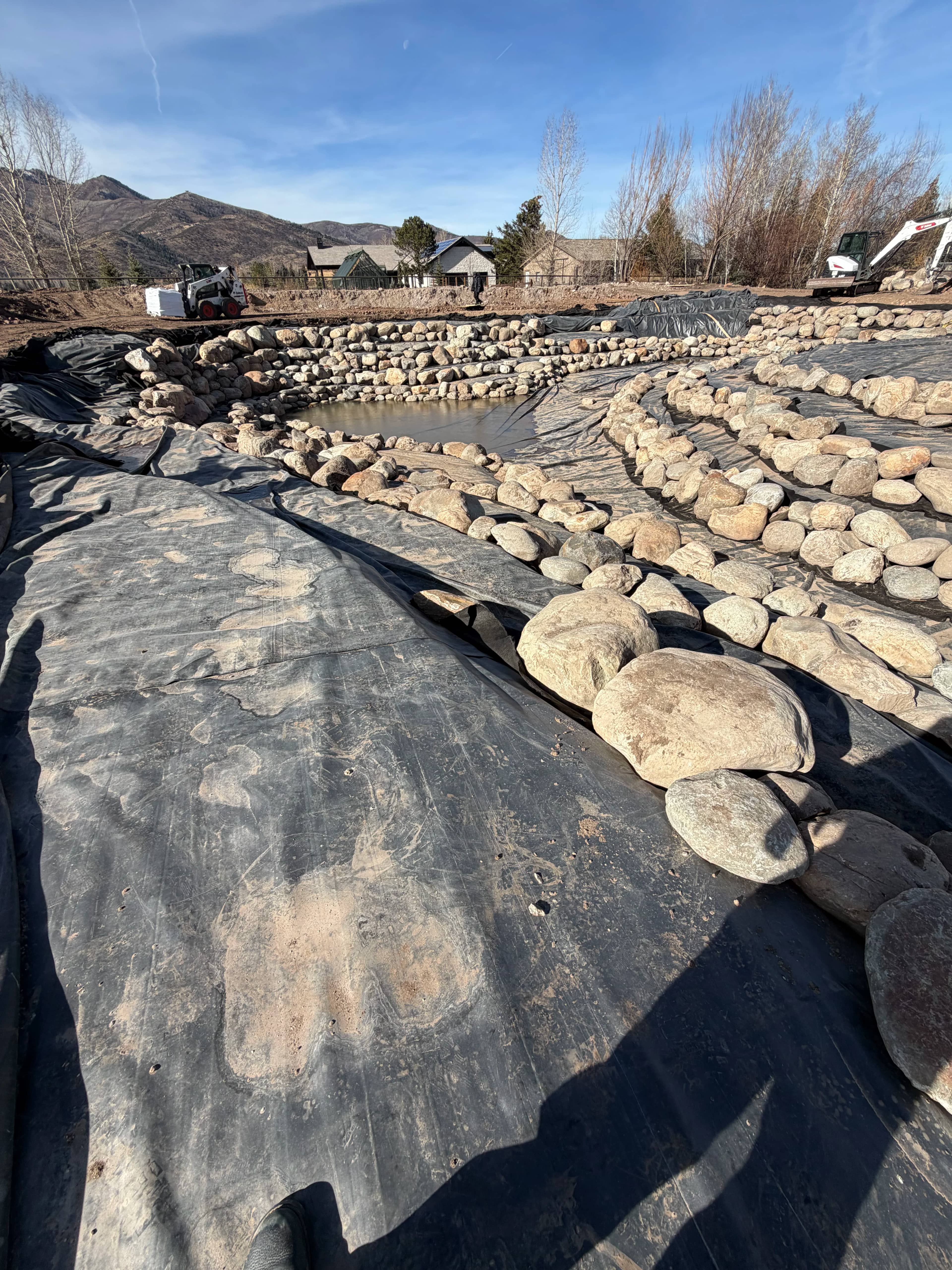 EPDM pond liner installation showing folds managed to create clean shelves and transitions