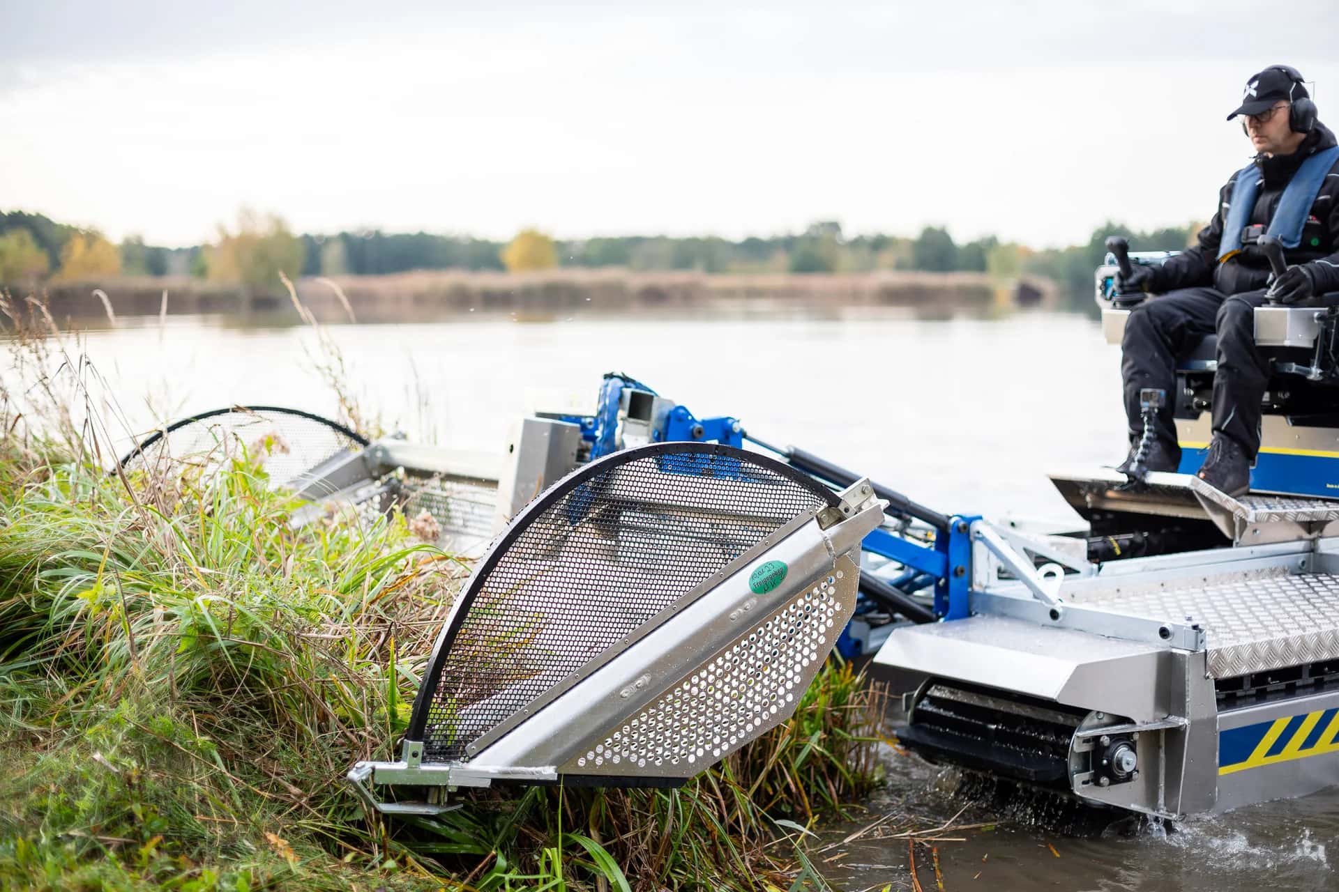 Water Raptor amphibious machine cutting and collecting pond vegetation in Utah