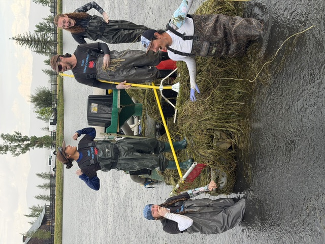 Five Utah Water Gardens team members smiling together during aquatic weed removal