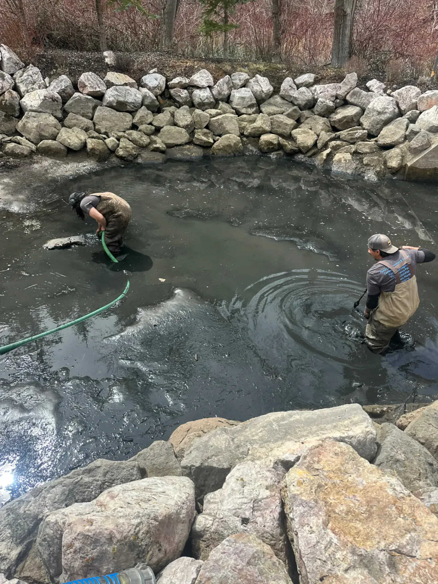 Heavy equipment dredging a pond shoreline